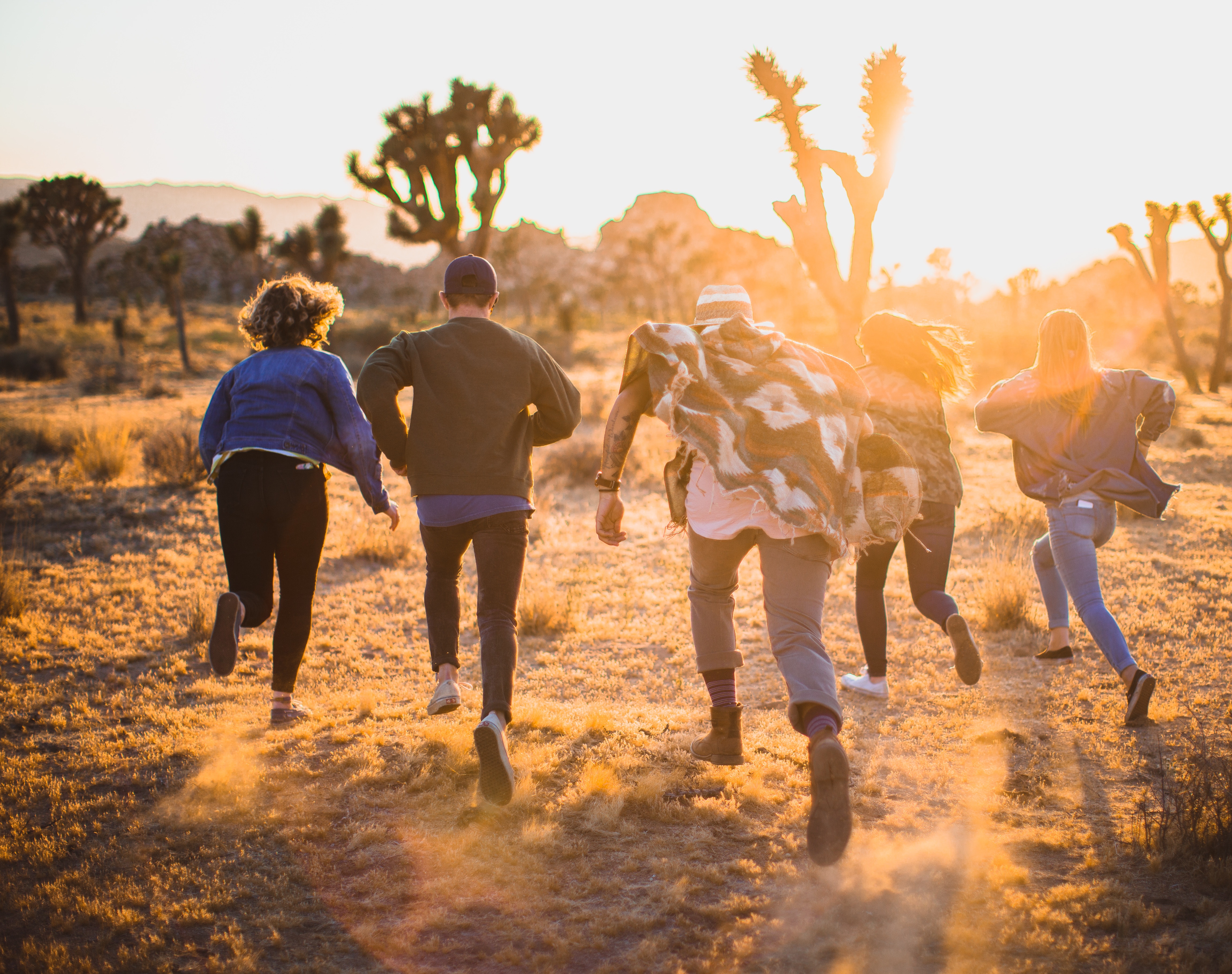 group of young adults running towards the horizon