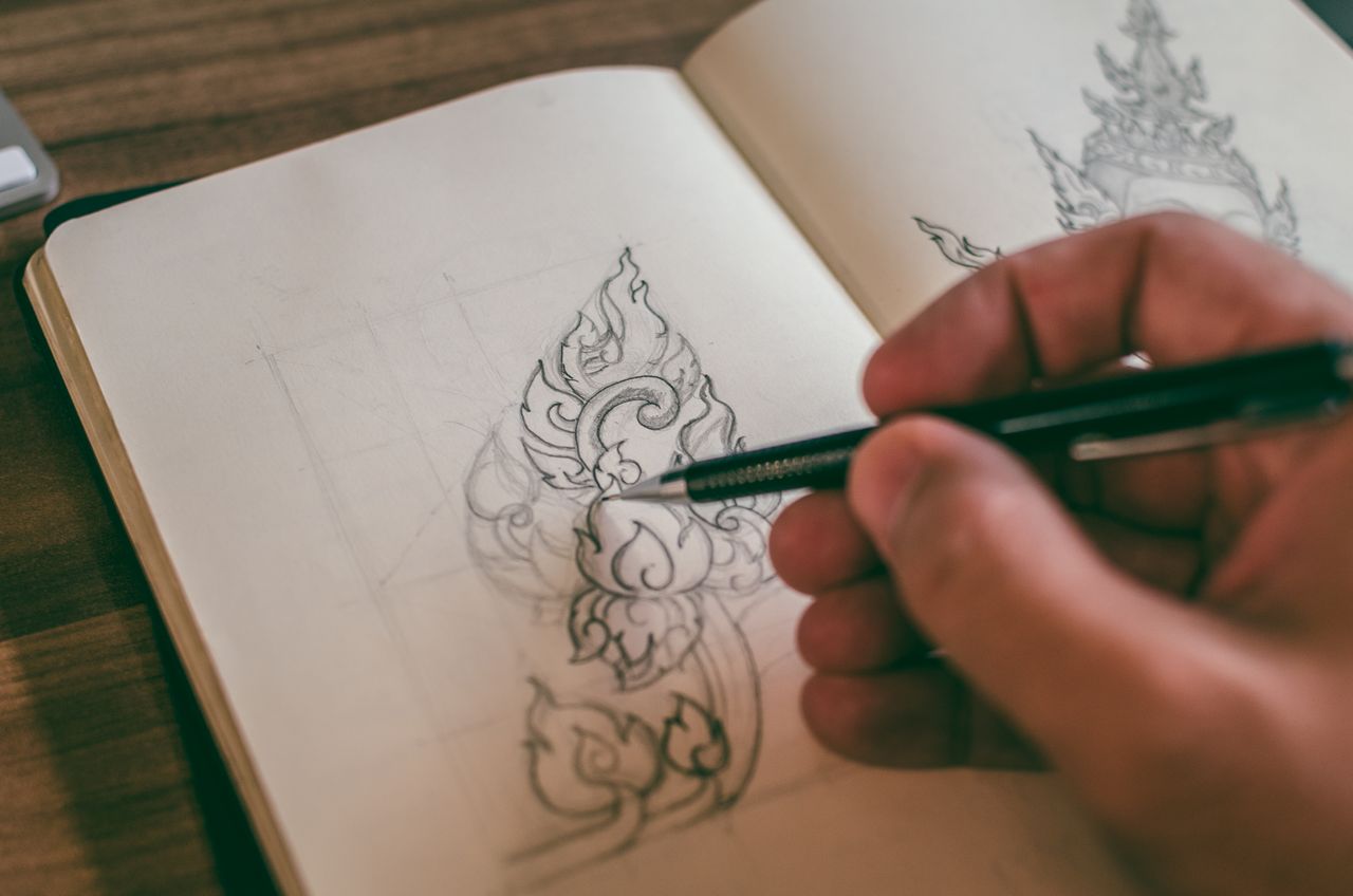 Designer sketching logo concepts in a sketchbook