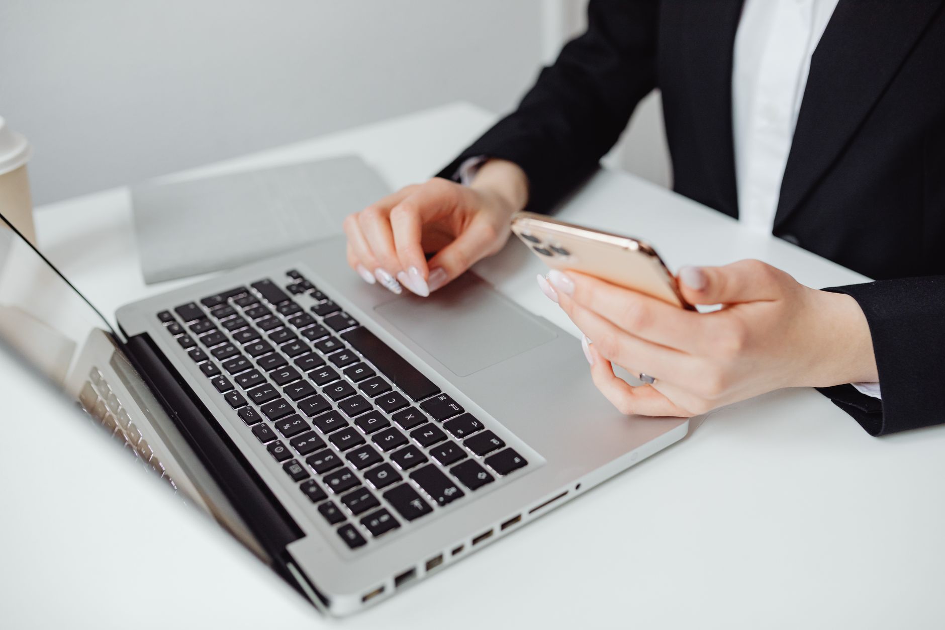 Professional checking business email on laptop and phone