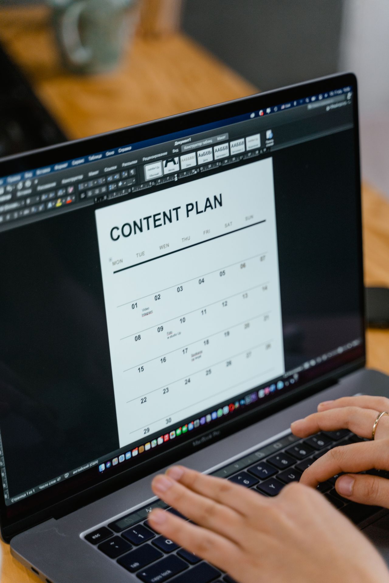 Hands typing a content plan on a laptop