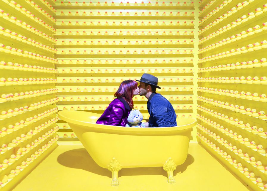 Social media management by a couple kissing in a bath tub